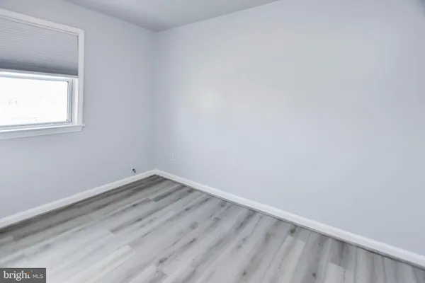 a view of a small space with wooden floor and a window