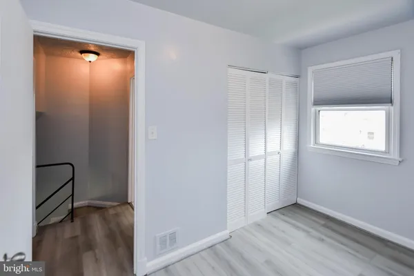 a view of an empty room with closet and a window
