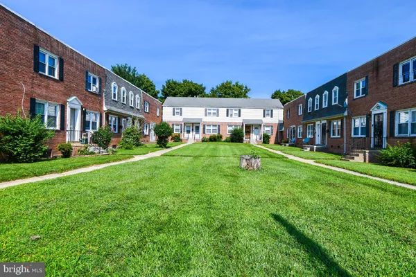 a backyard of a house with lots of green space and fountain