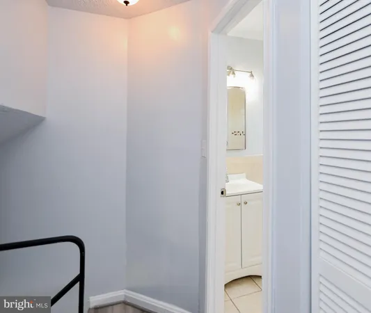 a white toilet sitting next to a bathroom sink and a mirror