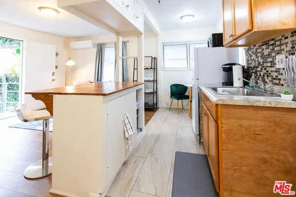 a kitchen with sink a refrigerator and wooden floor