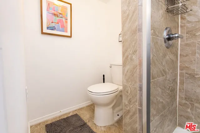 a bathroom with a toilet and a shower