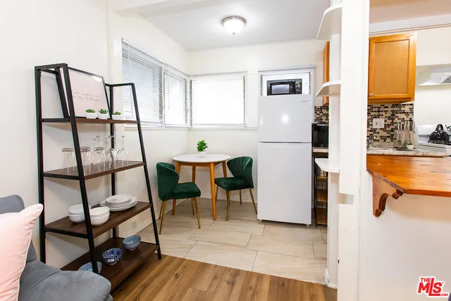 a kitchen with stainless steel appliances wooden floor and a refrigerator