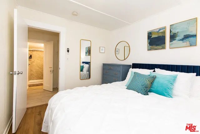 a bedroom with a bed and a painting on the wall