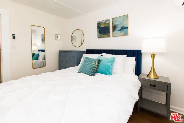 a bedroom with a bed and painting on the wall