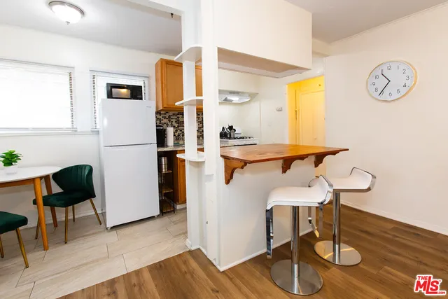 a view of dining room with wooden floor and dining table chairs