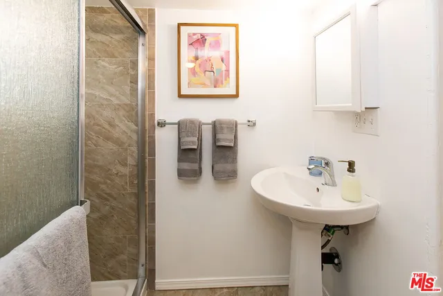a bathroom with a sink a mirror and a shower
