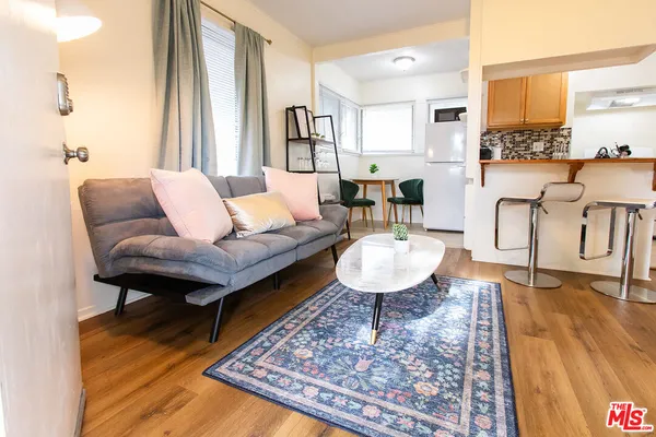 a living room with furniture a rug and a table