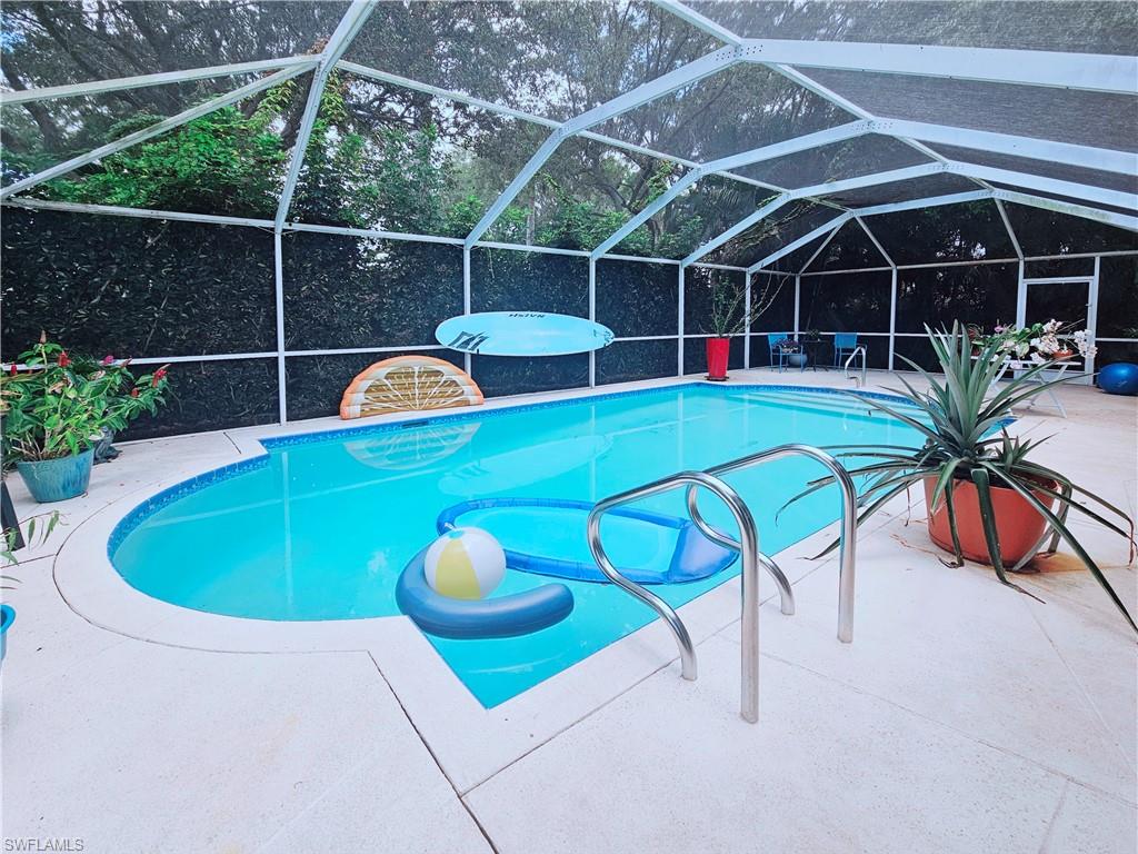 6708 Sloane Place Naples, FL 34104 - Photo 1 of 31 a view of a swimming pool with a seating space