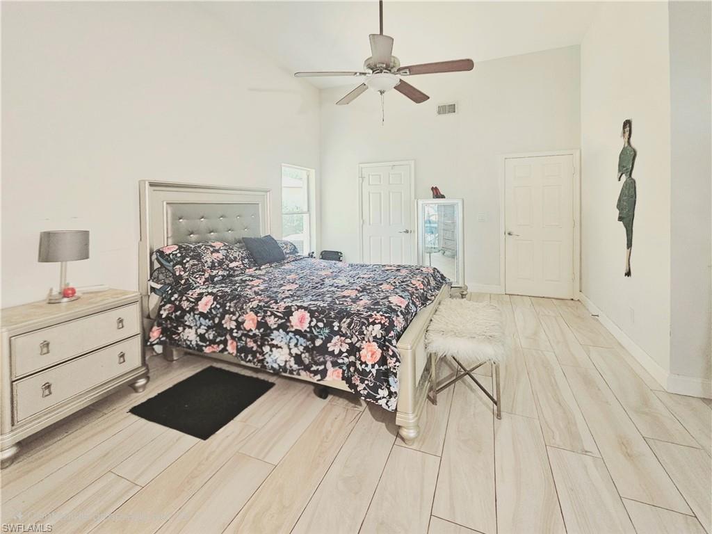 6708 Sloane Place Naples, FL 34104 - Photo 14 of 31 a bedroom with a bed and a chandelier