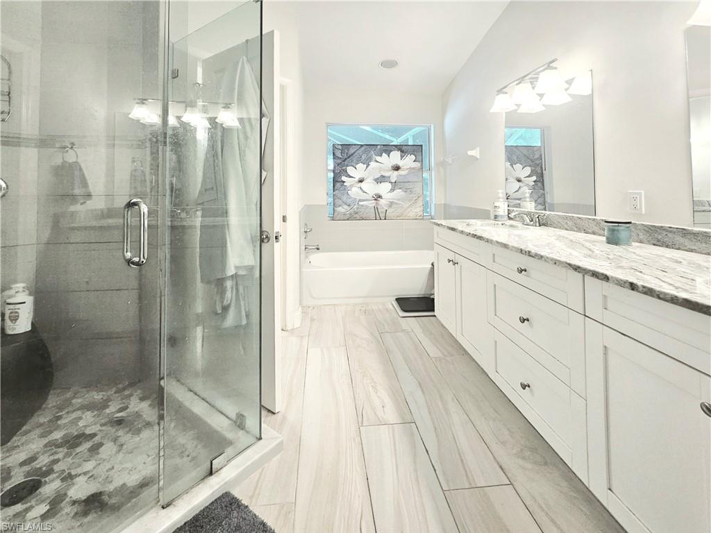6708 Sloane Place Naples, FL 34104 - Photo 16 of 31 a spacious bathroom with a granite countertop sink mirror and shower