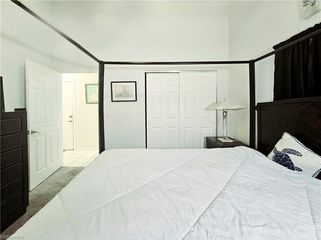 6708 Sloane Place Naples, FL 34104 - Photo 18 of 31 a bedroom with a bed and a closet