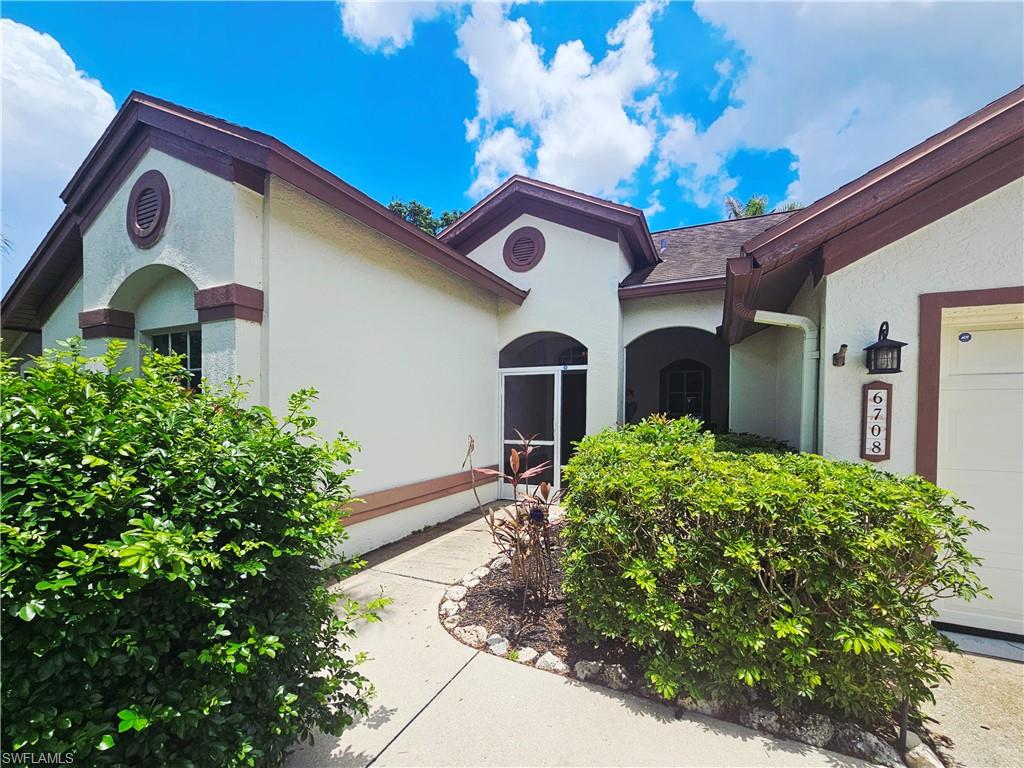 6708 Sloane Place Naples, FL 34104 - Photo 2 of 31 a front view of a house with garden