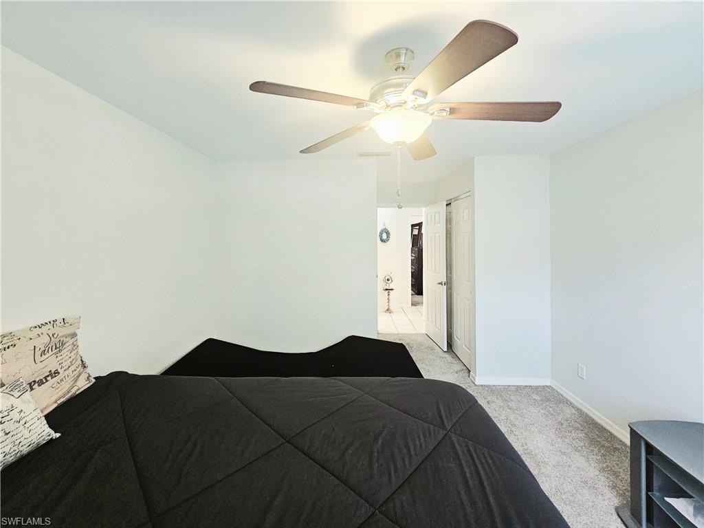 6708 Sloane Place Naples, FL 34104 - Photo 21 of 31 a bedroom with a bed and a chandelier