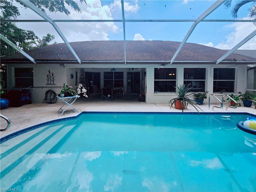 6708 Sloane Place Naples, FL 34104 - Photo 22 of 31 a front view of a house with sitting area and swimming pool