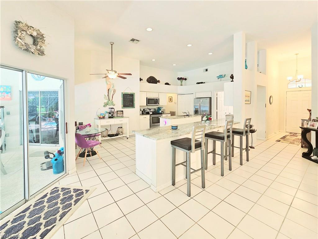 6708 Sloane Place Naples, FL 34104 - Photo 7 of 31 a large white kitchen with a large window
