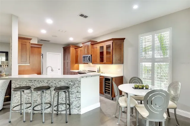 a dining table with chairs and kitchen view