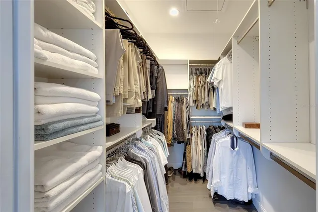 a view of walk in closet with clothes and shoes