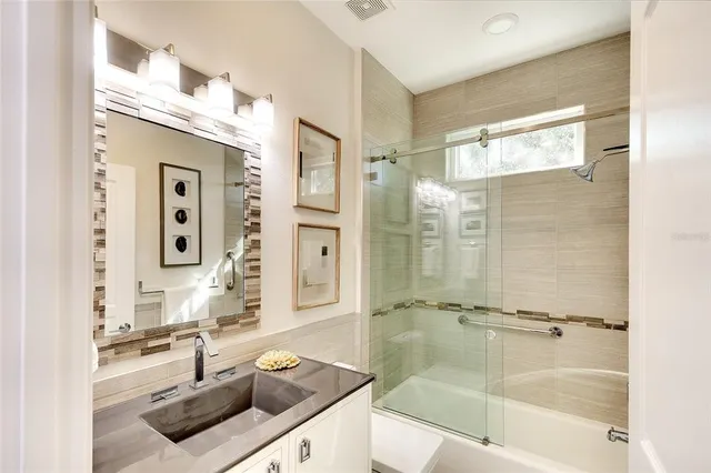 a bathroom with a sink tub vanity and mirror