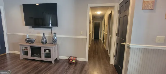 a view of a livingroom with wooden floor and a flat screen tv