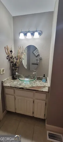 a bathroom with a granite countertop sink a mirror and vanity