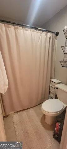 a bathroom with a toilet and a shower curtain
