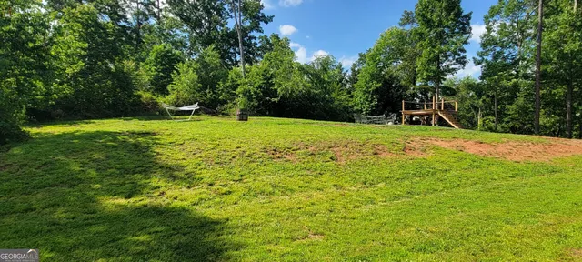 a backyard of a house with trees and wooden fence