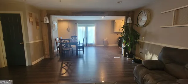 a living room with furniture wooden floor and a dining table