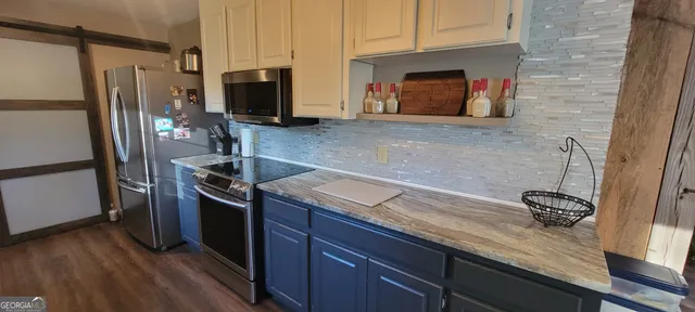a kitchen with granite countertop stainless steel appliances and wooden cabinets