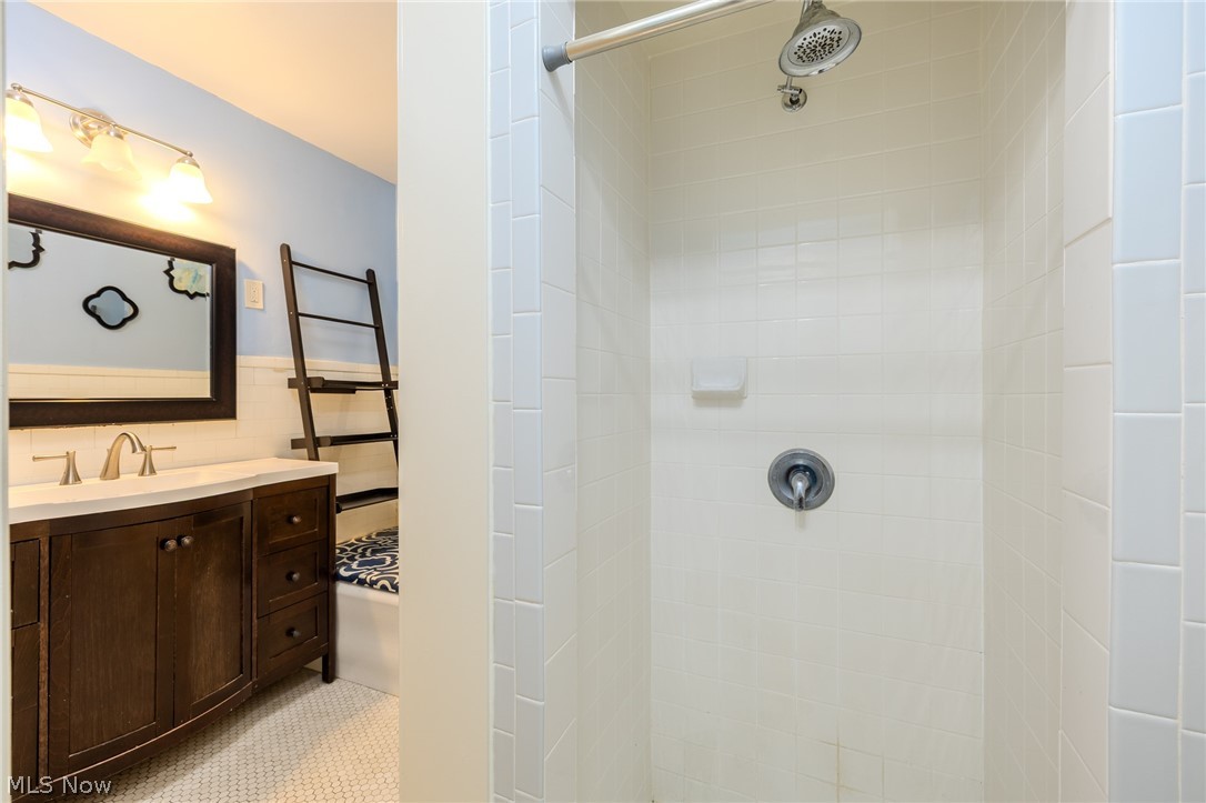2472 Overlook Road Cleveland Heights, OH 44106 - Photo 26 of 30 Full bathroom featuring tile walls, vanity, a tile shower, and wainscoting
