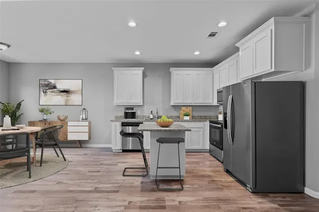a kitchen with refrigerator and cabinets
