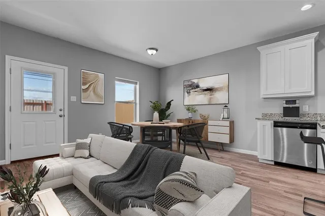 a living room with furniture two windows and a dining table