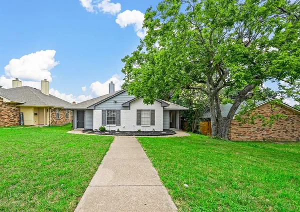a front view of a house with a yard and trees