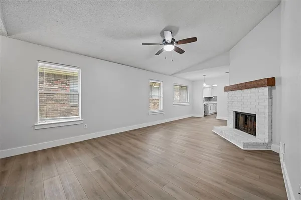 a view of empty room with wooden floor and fireplace