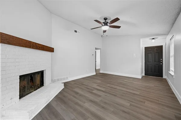 a view of empty room with wooden floor and fireplace