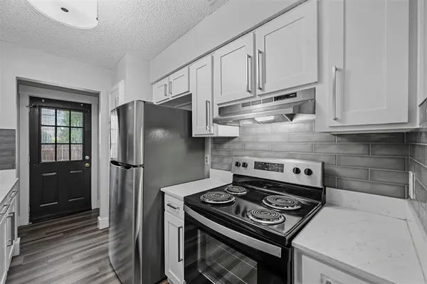 a kitchen with stainless steel appliances granite countertop a stove a refrigerator and a cabinets