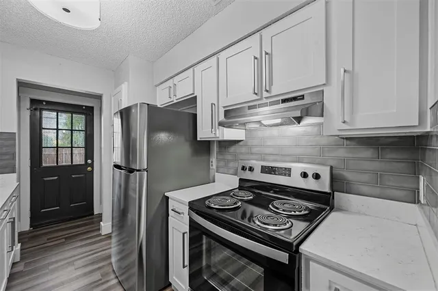 a kitchen with stainless steel appliances granite countertop a stove a refrigerator and a cabinets