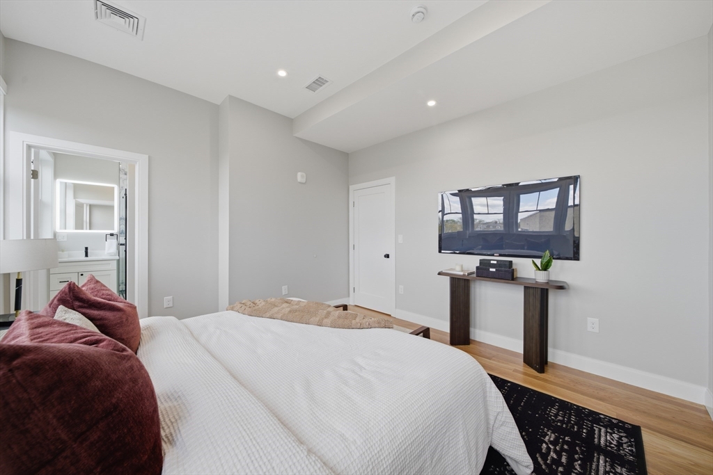 174 Walnut Street, Unit 3 Somerville, MA 02145 - Photo 32 of 38 a bedroom with a bed and a lamp on table