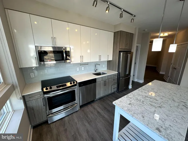 a kitchen with refrigerator cabinets and wooden floor