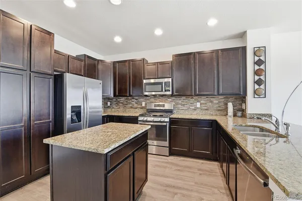 a kitchen with a refrigerator sink and cabinets