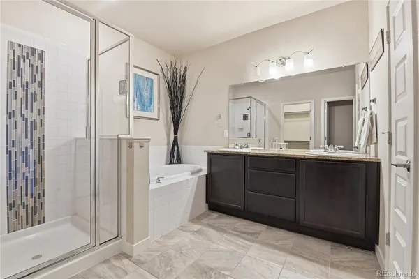 a bathroom with a double vanity sink mirror and shower