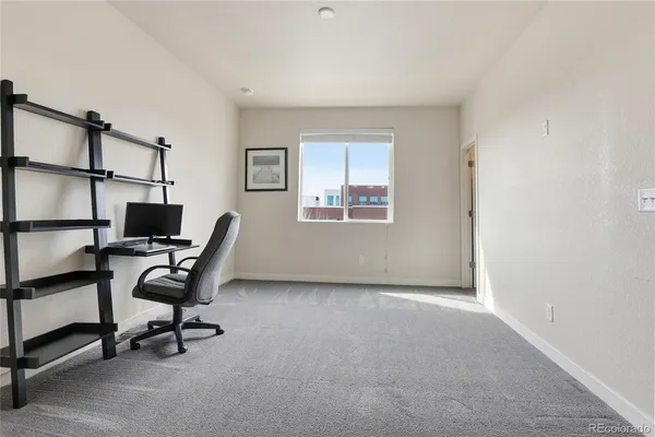 a view of a workspace with furniture and a window