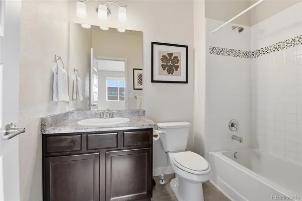 a bathroom with a granite countertop toilet sink and mirror