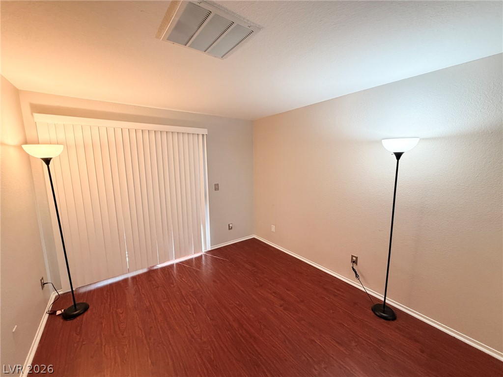 5211 South Lindell Road, Unit 105 Las Vegas, NV 89118 - Photo 2 of 19 Warm wood flooring and sliding glass doors define this versatile interior space.