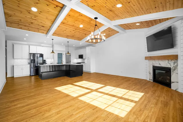 a living room with stainless steel appliances granite countertop furniture wooden floor and a view of kitchen