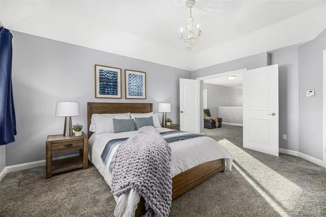 a bedroom with bed and a chandelier