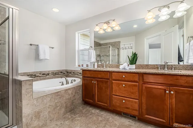 a spacious bathroom with a tub sink and mirror