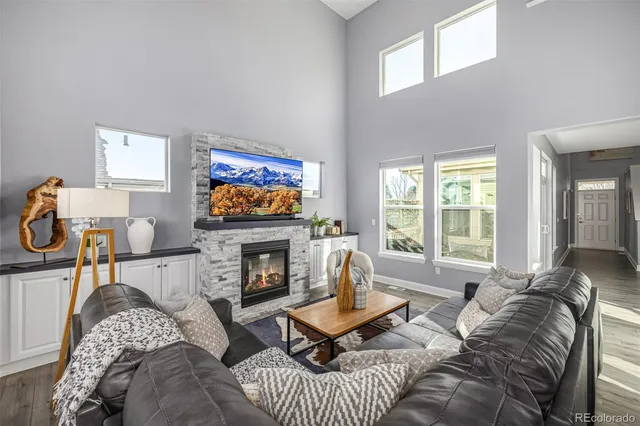 a living room with furniture a flat screen tv and a fireplace