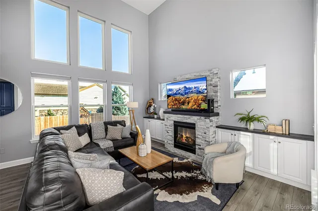 a living room with furniture a flat screen tv and a fireplace