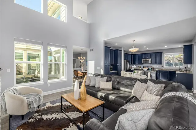 a living room with furniture kitchen and a large window